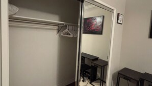 A room with a sliding closet door, a desk with a chair, and a mirror reflecting part of the room. - Pleasant 2-bedroom apartment with AC in Beverly Hills Near Rodeo Dr. (Beverly Hills)