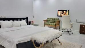 A modern bedroom with a large bed, a desk, a chair, and a television. - Cozy Duafe Villa/WI-FI/ 24hr Security/10mins to Airport (Adenta Municipality)