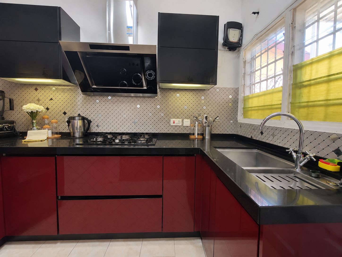 A modern kitchen with a gas stove, stainless steel appliances, and red cabinetry.