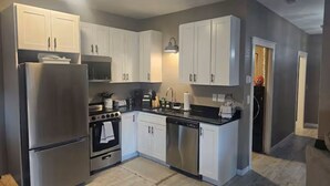 A modern kitchen with white cabinets, stainless steel appliances, and a central island.
