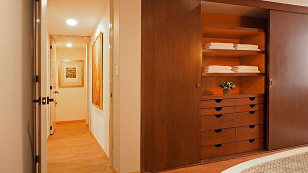 A hallway leading to a room with a wooden wardrobe containing shelves and drawers. - Polanco Family Terrace By The Local Way (Mexico City)