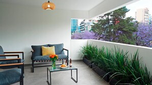 A balcony with a sofa, chairs, a coffee table, and potted plants. - Polanco Family Terrace By The Local Way (Mexico City)