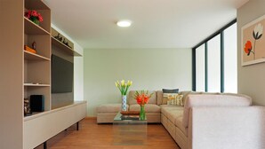 A modern living room with a sofa, a coffee table, and a TV on a stand. - Polanco Family Terrace By The Local Way (Mexico City)