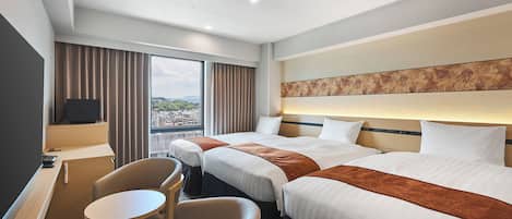 A hotel room with two beds, a desk, a chair, and a large window with curtains.