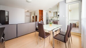 Een moderne keuken met een eetgedeelte, een inbouwoven en een groot raam.