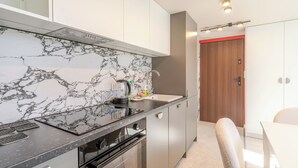 Una cocina moderna con salpicadero de mármol, electrodomésticos de acero inoxidable y una puerta de madera.