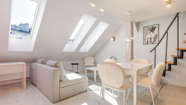 Un loft moderno con comedor, sofá y escalera.