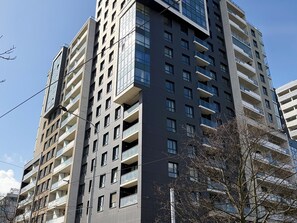 A multi-story building with balconies, a clear sky, and a visible sign with letters. - Odra Tower Harmony Apartment (Wrocław)