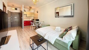 Ett kompakt hotellrum med en säng, ett nattduksbord och ett litet skrivbord med en stol.