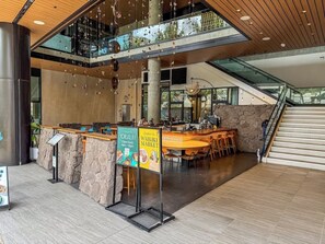 A modern indoor space with a reception desk, seating area, and a staircase. - [New] Walk Score 95 | Mtn+City View | Kitchenette (Honolulu)