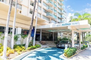 A hotel entrance with a covered area, palm trees, and a sign reading 'AQUA ALOHA SURF'. - [New] Walk Score 95 | Mtn+City View | Kitchenette (Honolulu)