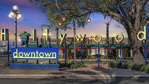 En skylt med texten ”Hollywood Downtown” och ett palmträd.