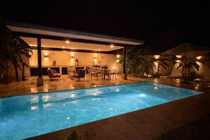 A swimming pool with lounge chairs and tables, surrounded by palm trees and a covered seating area. - Iks' Túun Mérida Department (Conkal)