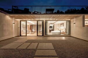 Um edifício moderno com entrada coberta, banheiro visível com banheira e interior bem iluminado.