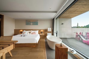 Un hotel moderno con una cama grande, una bañera, suelo de madera, vistas a la ciudad y un cuadro en la pared.
