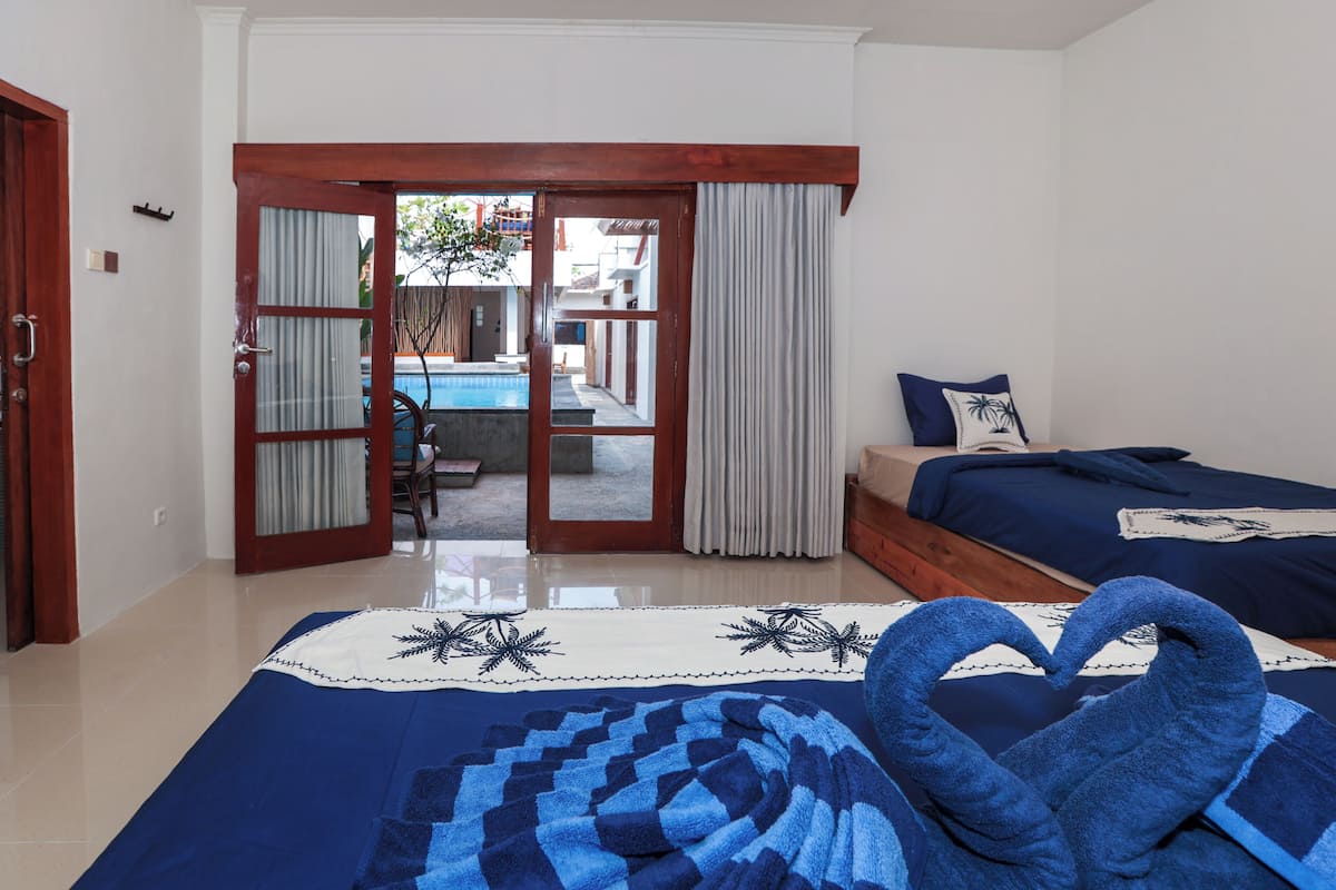 Habitación de hotel con cama, vista a una piscina y puerta que da al exterior.