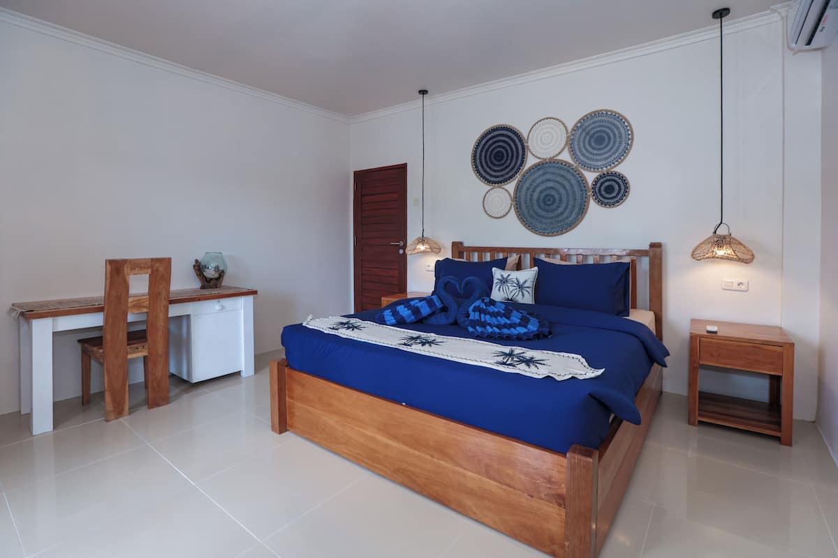 Un dormitorio con una cama de madera, un escritorio y una mesita de noche.