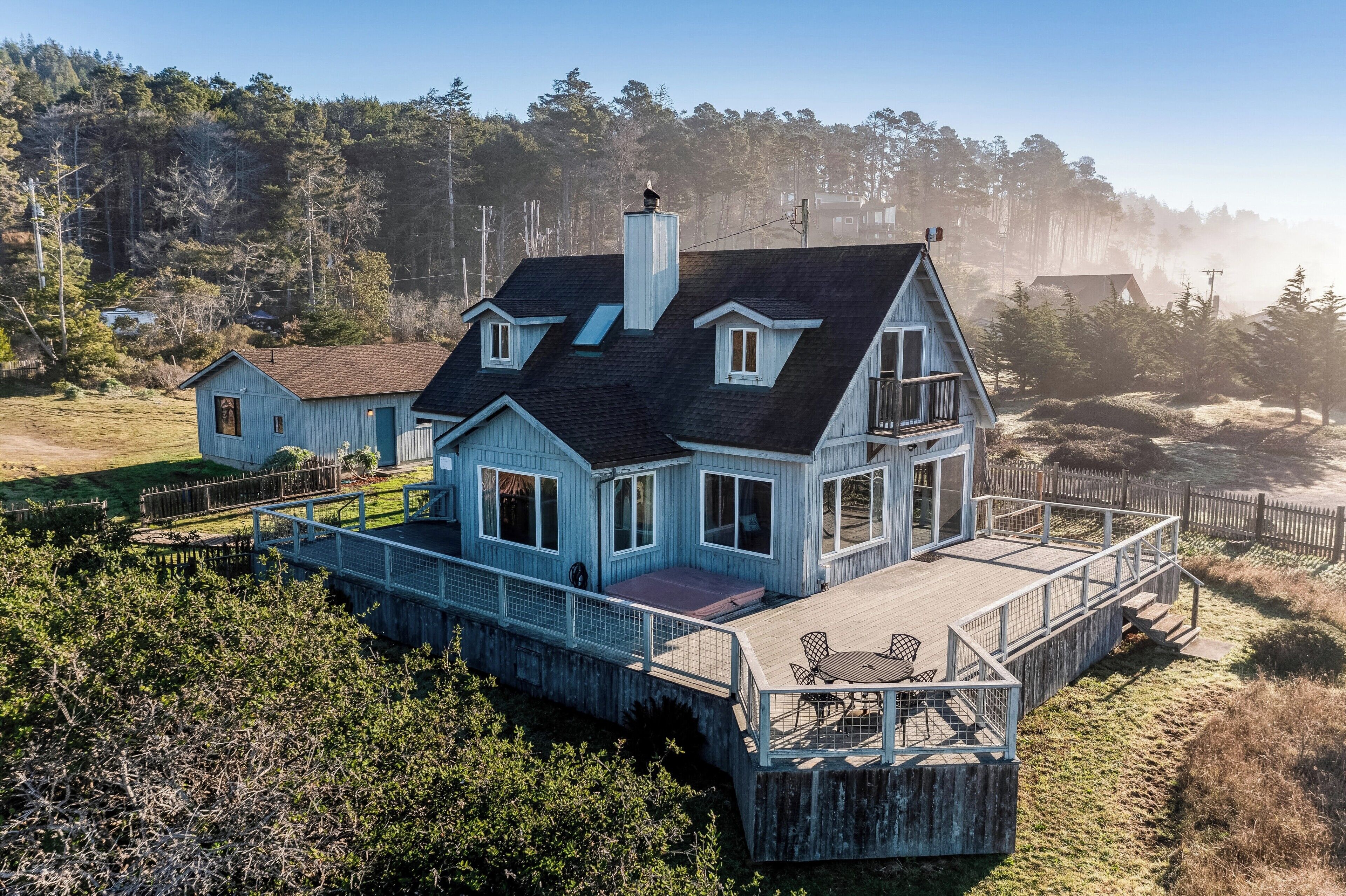 A house with a deck, multiple windows, and a chimney.