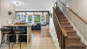 A kitchen with a bar area, a staircase, and a view of the outdoors.
