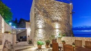 A stone building with a balcony, outdoor seating, and potted plants. - in Makarska mit privatem Pool und außergewöhnlic by Interhome (Makarska)