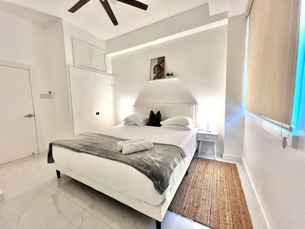 Una camera da letto moderna con un letto, comodini, una mensola a parete e una ventola a soffitto.