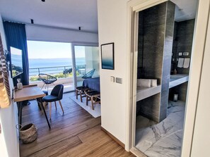 A modern room with a balcony, a dining area, and a bathroom with a marble floor. - Moderne Villa mit Infinity-Pool im Bergdorf Veliko Brdo by Interhome (Makarska)
