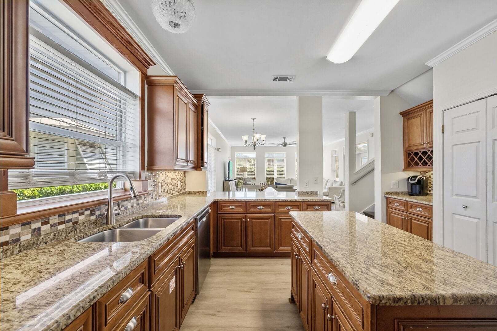 A kitchen with wooden cabinets, granite countertops, and a central island.