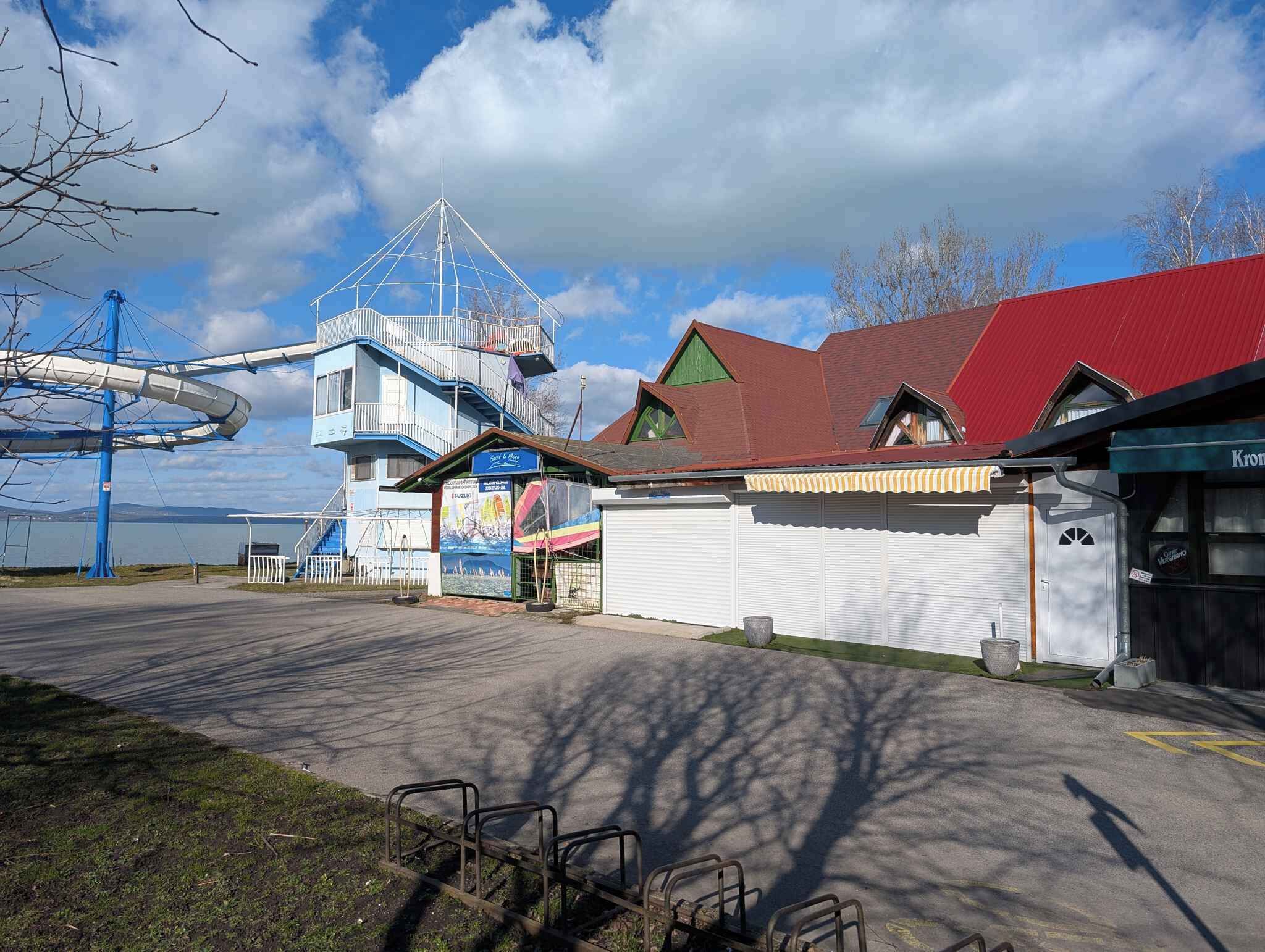 Ein Küstengebäude mit einer blau-weißen Fassade, einem roten Dach und einer Wasserrutsche.
