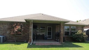 A single-story brick house with a covered porch, a small lawn, and a tree. - Peaceful 3-bedroom house in charming Stillwater for your getaway (Stillwater)