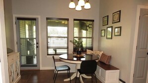 A dining area with a round table, two chairs, a bench, and a wall-mounted light fixture. - Peaceful 3-bedroom house in charming Stillwater for your getaway (Stillwater)