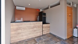 A reception area with a wooden reception desk, a wall-mounted air conditioner, and a closed door labeled "Staff Only". - HOTEL R9 The Yard Minamiarupusu (Minami-Alps)