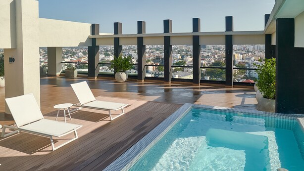 A rooftop pool area with lounge chairs and a view of the city. - 3BR Elegant Spot Downtownsd Family Pool (Santo Domingo)