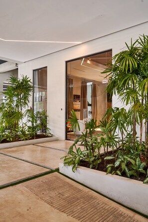 A modern building with large glass doors, indoor plants, and a clean, minimalist design. - 3BR Elegant Spot Downtownsd Family Pool (Santo Domingo)