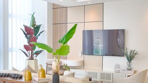 A modern living room with a sofa, coffee table, and decorative plants. - The LUX Natural Art Downtownsd Pool Gym 2BR (Santo Domingo)
