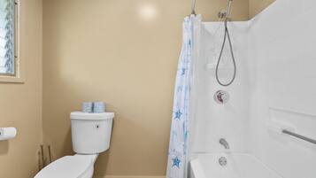 Ein Badezimmer mit Toilette, Dusche und Badewanne.