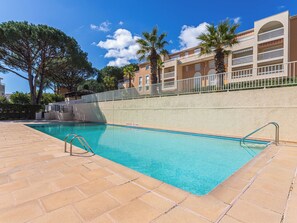 A swimming pool with clear blue water, surrounded by a tiled deck. - Santa Barbara by Interhome (Cavalaire)