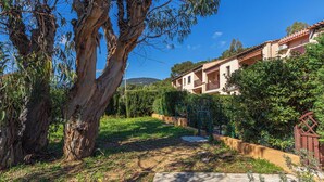 A residential area with a large tree, a pathway, and a building with multiple balconies. - Des Moulins by Interhome (Cavalaire)