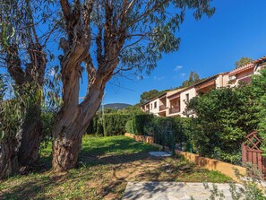 A residential area with a large tree, a pathway, and a building with multiple balconies. - Des Moulins by Interhome (Cavalaire)