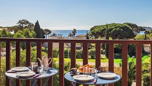 A balcony with tables set for breakfast overlooking a coastal view. - Des Moulins by Interhome (Cavalaire)