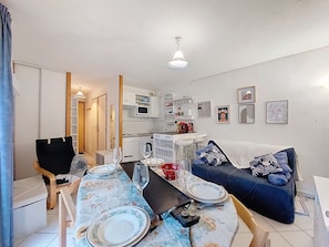 A compact living space with a dining area, kitchenette, and seating area. - Bel Alp by Interhome (Saint Gervais)