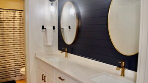 A bathroom with two sinks, a large mirror, and a towel rack. - Fully Remodeled & Newly Furnished Browne's Addition Condo - Dog Friendly! (Spokane)