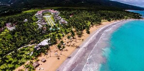 An aerial view of a resort with a beachfront, palm trees, and a swimming pool. - Sublime LUX Condo Terrenas Jaccuzi Beachfront (Las Terrenas)