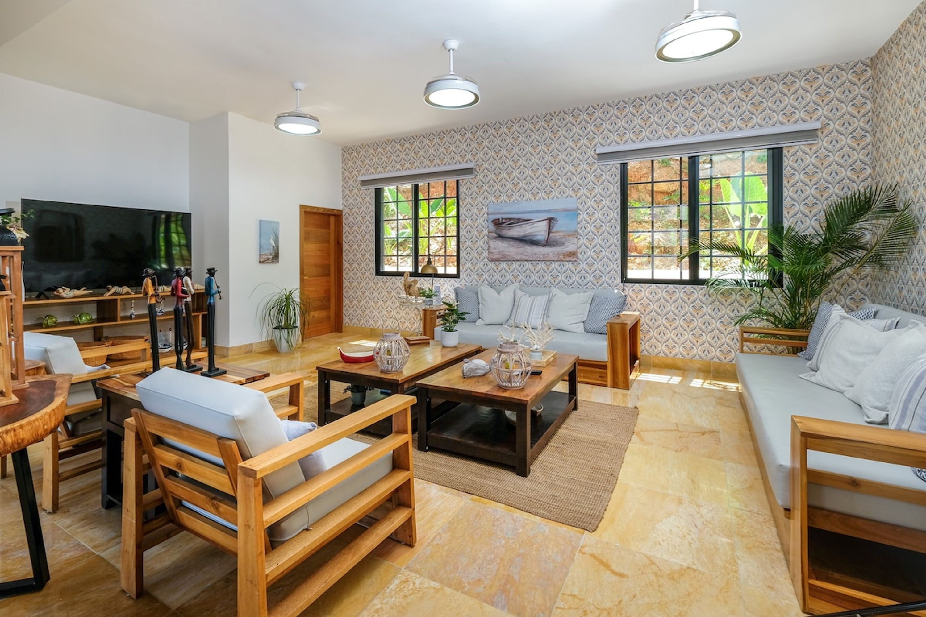 A spacious living room with a sofa, chairs, a coffee table, and a TV.