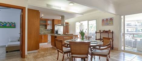 A spacious kitchen with a dining area, wooden cabinets, and a large window.