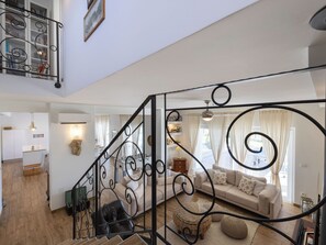A spacious living area with a staircase, a sofa set, and a dining area with a kitchen in the background. - Vacation home Olivia by Interhome (Šestanovac)