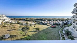 A coastal residential area with modern architecture, a clear view of the sea, and a well-maintained grassy area. - Les Grenadines by Interhome (La Grande Motte)