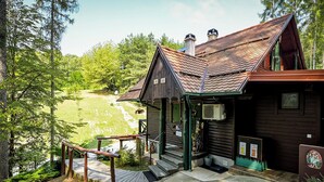 Une cabane en bois avec un toit en pente, une véranda et un petit escalier menant à l’entrée.