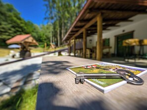 A wooden table with a map and a metal key. - Pine Hill by Interhome (Klenovnik)