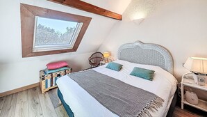 A bedroom with a skylight, a bed with pillows, a bedside table, and a lamp. - Les Jardins de la Plage by Interhome (Carnac)