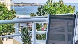 A balcony with a view of the ocean, a chair, and some plants. - Le Hoche by Interhome (Quiberon)